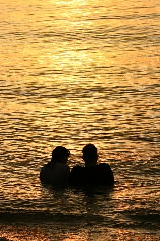 couple in water at sunset