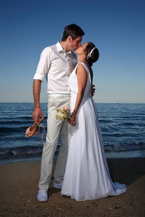 bride and groom kissing on beach