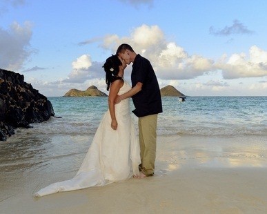 newlyweds kissing in ocean